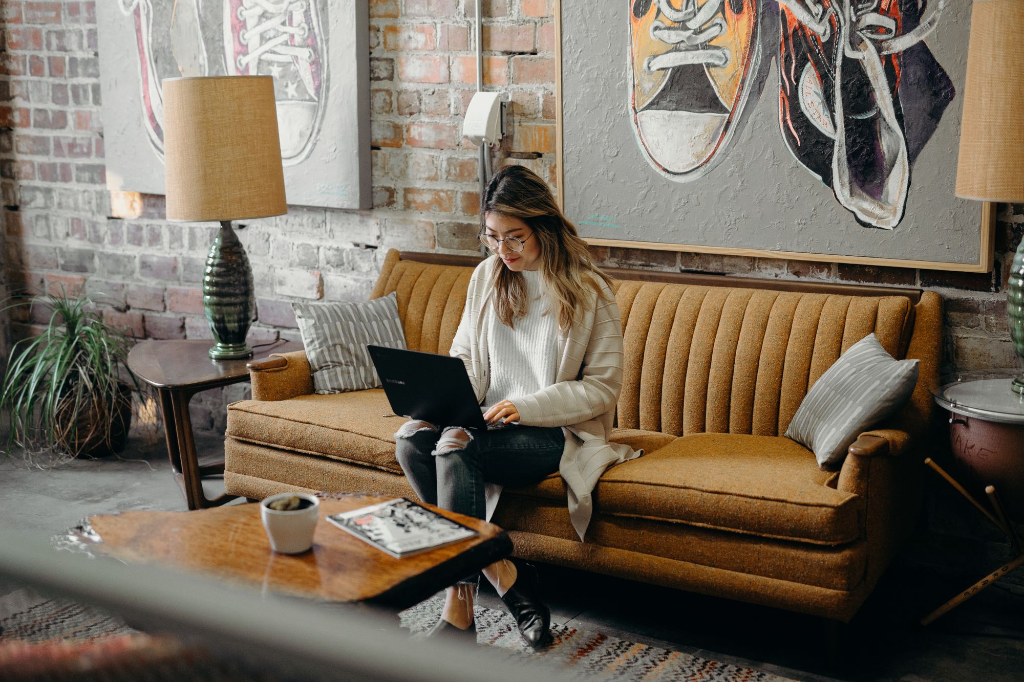 Woman using a laptop while sitting on a sofa