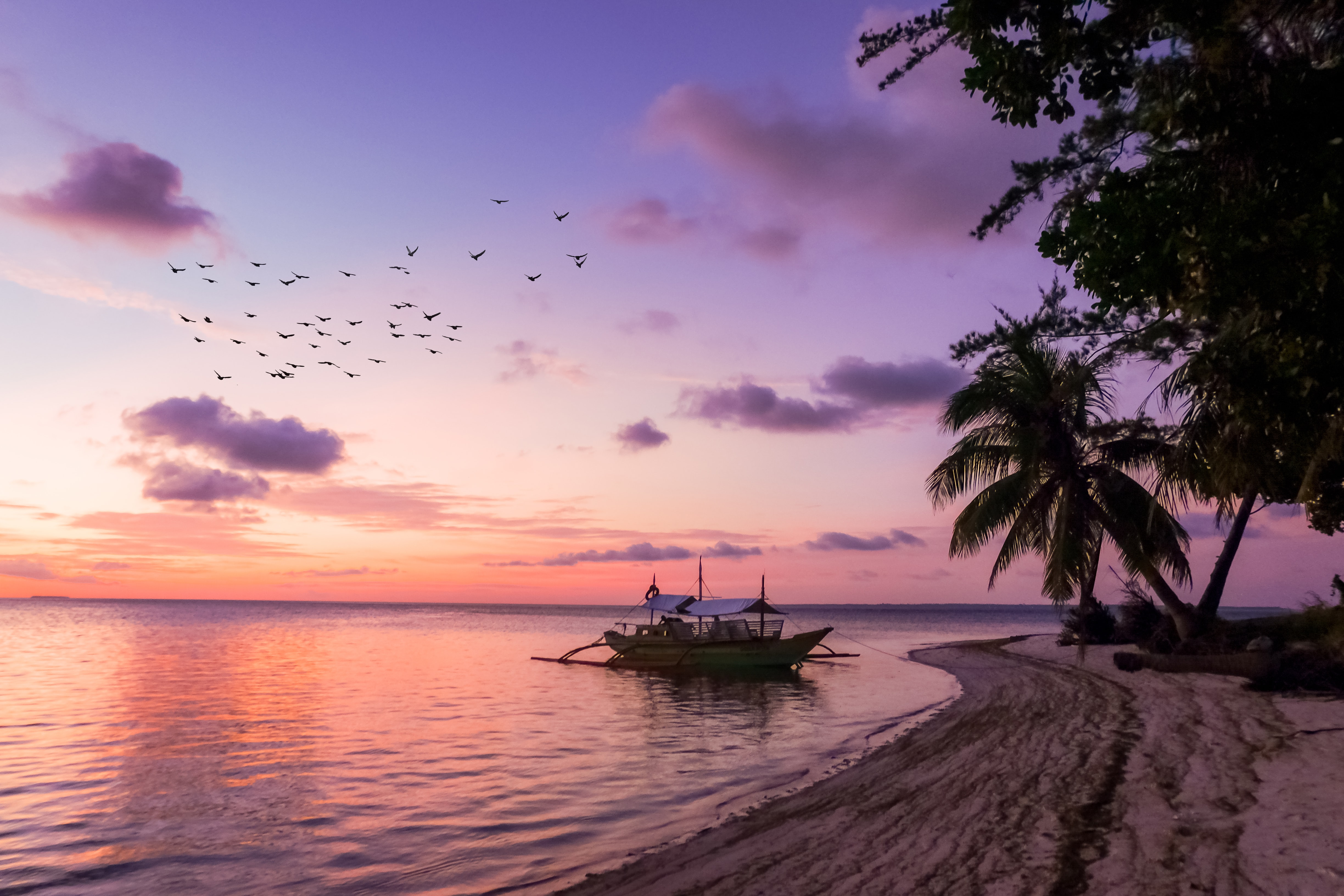 Purple sky over a traditional Filipino boat on water, Balabac, Philippines