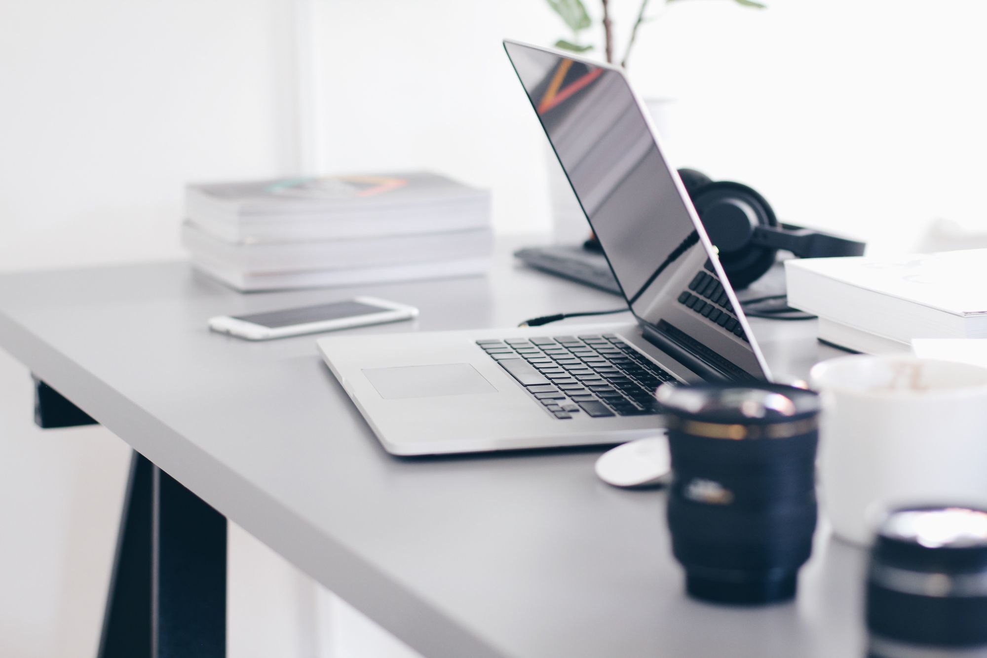 Half-open MacBook on an office desk with other office items